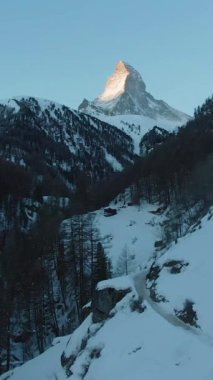 Matterhorn Dağı ve Ormanı Kış Sabahı. İsviçre. Hava görüntüsü. Drone İleri Uçuyor. Dikey Video