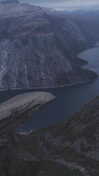 ノルウェーのトロルトゥンガ クリフ 夏のトロール トンガ ロック エアリアルショット ドローンが前方に向かって飛んでいる カメラが傾いている バーティカルビデオ — ストック動画