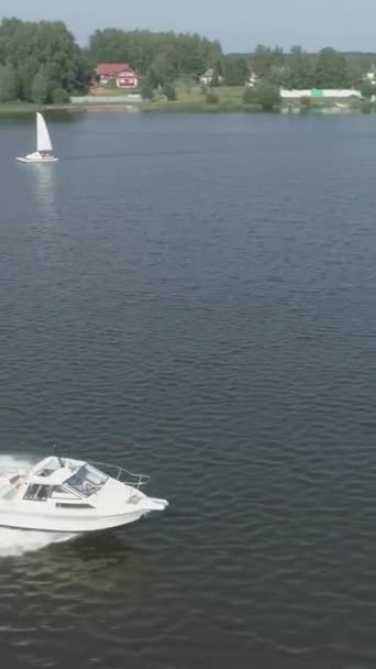 艳阳天 豪华高速汽艇在海上疾驰 空中景观 无人机绕着船飞来飞去 照相机倾斜下来了 射中目标 垂直录像 — 图库视频影像