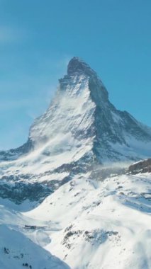 Güneşli kış gününde Matterhorn Dağı. İsviçre. Hava görüntüsü. Orta boy shot. İnsansız hava aracı yandan uçuyor. Dikey Video