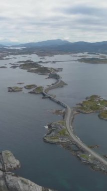 Norveç 'teki Atlantik Okyanusu Yolu' nda, yüksek irtifadan. Hava görüntüsü. İnsansız hava aracı yörüngeleri. Dikey Video