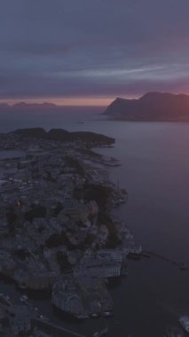 Norveç 'teki Alesund City Bulutlu Gökyüzü ile Renkli Gün Batımında. Hava görüntüsü. Drone yörüngede dönüyor. Dikey Video