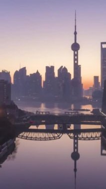 Şafak vakti panoramik Şangay silueti. Lujiazui Finans Bölgesi ve Huangpu Nehri. Çin. Hava Hiper Hatası. İHA yukarı ve ileri doğru uçuyor. Atış ayarlanıyor. Dikey Video