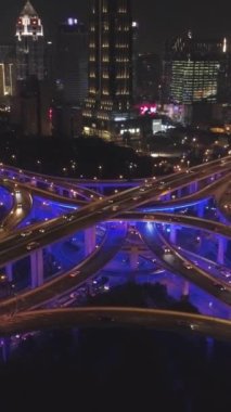 Gece Mavi Aydınlatma ile Yükseltilmiş Yol Üstgeçidi. Şangay, Çin. Hava görüntüsü. Kamera Panning 'de. Atış ayarlanıyor. Dikey Video