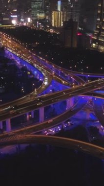 Gece Mavi Aydınlatma ile Yükseltilmiş Yol Üstgeçidi. Şangay, Çin. Hava görüntüsü. Kamera Panning 'de. Atış ayarlanıyor. Dikey Video