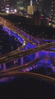 Gece Mavi Aydınlatma ile Yükseltilmiş Yol Üstgeçidi. Şangay, Çin. Hava görüntüsü. Kamera Panning 'de. Atış ayarlanıyor. Dikey Video