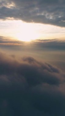 Gün doğumunda ağır gri kara bulutların üzerinde ilerliyorlar. Havadan aşırı hızlanma. Dikey Video