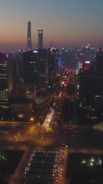 Alacakaranlık 'ta Şangay Skyline. Lujiazui Bölgesi ve Century Bulvarı. Hava görüntüsü. Drone ileri ve yukarı doğru uçuyor. Atış ayarlanıyor. Dikey Video