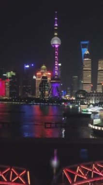 Gece vakti Şangay 'ı aydınlattı. Lujiazui Bölgesi ve Huangpu Nehri. Çin. Hava görüntüsü. Drone yukarı doğru uçuyor. Atış ayarlanıyor. Dikey Video