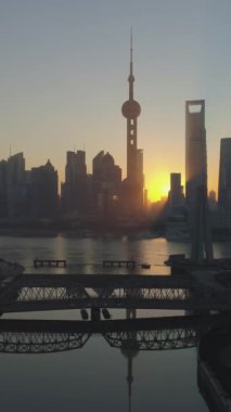 Gün doğumunda Şanghay 'ın silueti panoramik. Lujiazui Finans Bölgesi ve Huangpu Nehri. Çin. Hava görüntüsü. Drone ileri ve yukarı doğru uçuyor. Atış ayarlanıyor. Dikey Video