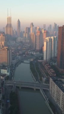 Güneşli bir sabahta Şangay Skyline. Puxi Bölgesi. Çin. Hava görüntüsü. Drone ileri ve yukarı doğru uçuyor. Atış ayarlanıyor. Dikey Video