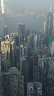 Hong Kong Skyline ve Victoria Limanı. Hava görüntüsü. İHA ileri uçuyor, Kamera yukarı eğiliyor. Atış ayarlanıyor. Dikey Video