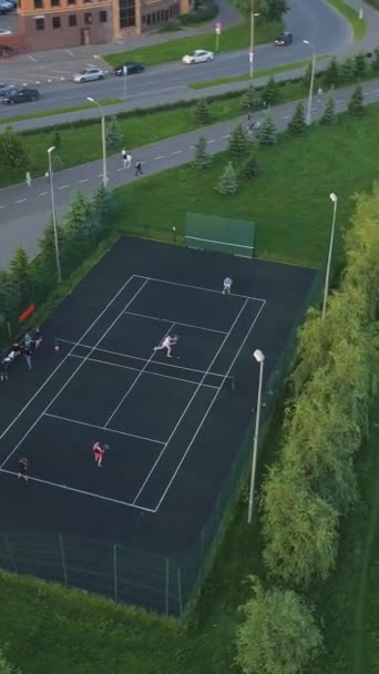 在绿城公园的院子里打网球的运动员 走在人行道上的人 空中风景 垂直录像 — 图库视频影像