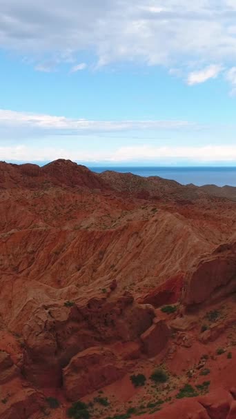 在红峡谷的岩石上飞来飞去 火星人的风景湖水和蓝天空中风景 垂直录像 — 图库视频影像