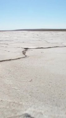 Beyaz tuz ve çatlaklarla dolu Tuz Gölü. Hava görüntüsü. Dikey Video