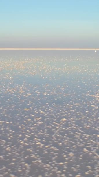 塩湖には白い塩が入っています ドローンが右に飛んでいる 空からの眺め バーティカルビデオ — ストック動画