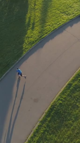 사람은 아침에 공원에서 블레이딩입니다 드론은 수컷을 따라갑니다 비디오 — 비디오