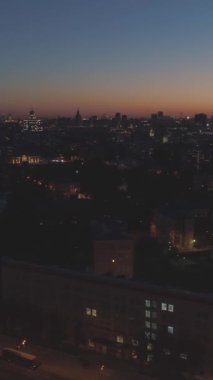 Akşam Alacakaranlığı 'nda Moskova Skyline' ı aydınlattı. - Rusya. Hava görüntüsü. İnsansız hava aracı yan ve yukarı doğru uçuyor. Dikey Video