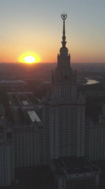 Moskova Devlet Üniversitesi ve Sunny Morning 'deki şehir manzarası. - Rusya. Hava görüntüsü. Drone ileri ve yukarı doğru uçuyor ve Spire 'a yaklaşıyor. Dikey Video