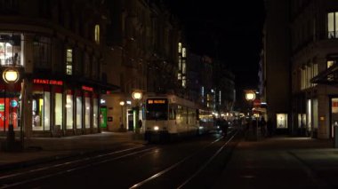 GENEVA, SWitzERLAND - 20 Şubat 2024: Tram ve Gece Cenevre Caddesi 'ndeki İnsanlar.