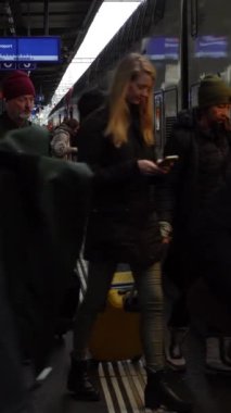 GENEVA, SWitzERLAND - 20 Şubat 2024: İnsanlar Cenevre 'de Cornavin Tren İstasyonu' nda trenden iniyorlar. Dikey Video