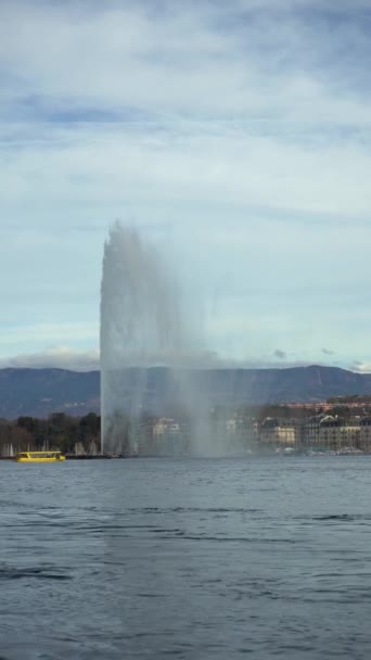 ジュネーブの水噴水とフェリーは曇りの日に通過します スイス 垂直ビデオ — ストック動画