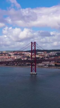 Ponte 25 de Abril Askı Köprüsü ve Lisbon Skyline. 25 Nisan Köprüsü. Mavi Gök ve Kümülüs Bulutları. Portekiz. Hava görüntüsü. Yörüngede. Dikey Video