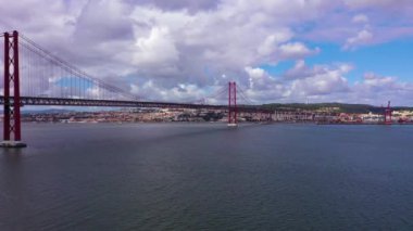 Ponte 25 de Abril Askı Köprüsü ve Lisbon Skyline. 25 Nisan Köprüsü. Mavi Gök ve Kümülüs Bulutları. Portekiz. Hava görüntüsü. Drone İleri ve Yukarı Uçuyor