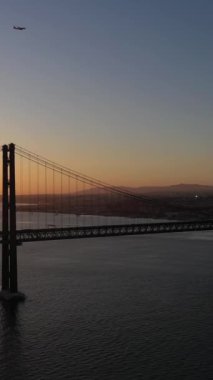 Ponte 25 de Abril Askı Köprüsü Sunset 'te. 25 Nisan Köprüsü. Portekiz. Altın Saat. Hava görüntüsü. Yörüngede. Dikey Video