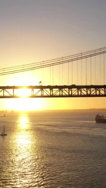 夕阳西下25号阿布里埃尔吊桥和帆船的轮廓 4月25日大桥葡萄牙 空中景观 垂直录像 — 图库视频影像
