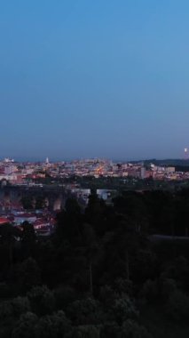 Lisbon Skyline ve Akşam Alacakaranlığı 'ndaki Monsanto Ormanı Parkı. Aguas Livres Aqueduct. Mavi Saat. Portekiz. Hava görüntüsü. Drone ileri ve yukarı hareket ediyor. Şutu göster. Dikey Video