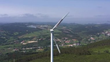 Güneşli bir günde Portekiz 'in Yeşil Kırsal Bölgesinde Bıçaklı Rüzgar Türbini. Hava görüntüsü. Alternatif Yenilenebilir Enerji. Yörüngede