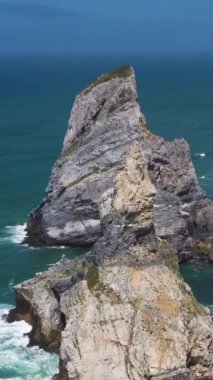 Ursa Sahili, İki Deniz Yığını, Kayalıklar ve Güneşli Gün 'de Atlantik Okyanusu Dalgaları. Portekiz. Hava görüntüsü. Yörüngede, yukarı doğru. Dikey Video