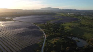 ALENQUER, PORTUGAL - 15 Nisan 2024: Portekiz 'de Sunset' teki Büyük Fotovoltaik Güneş Panelleri Alanı. Güneş ışığı yansıması. Hava görüntüsü. Drone İleri Gidiyor