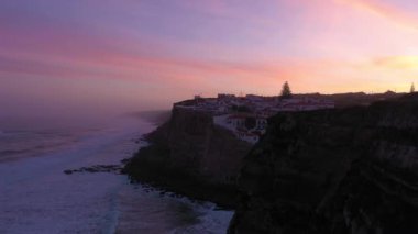 Azenhas, Sabah Alacakaranlığı, Atlantik Okyanusu 'nun Kayalıkları ve Dalgaları' nda Portekiz 'deki Mar Village' ı yapıyor. Hava görüntüsü. Drone ileri ve yukarı hareket ediyor. Pembe Gök. Çekim Kuruluyor