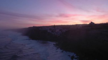 Azenhas, Sabah Alacakaranlığı, Atlantik Okyanusu 'nun Kayalıkları ve Dalgaları' nda Portekiz 'deki Mar Village' ı yapıyor. Hava görüntüsü. Drone ileri ve yukarı hareket ediyor. Görüntü Görüntüsü