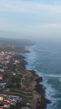 Portekiz kıyıları, Azenhas yakınlarında. Atlantik Okyanusu 'nun Kayalıkları ve Dalgaları. Hava görüntüsü. Drone ileri gidiyor. Dikey Video