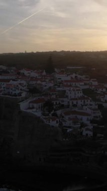 Azenhas, Portekiz 'de Sunrise' da Mar Village, Atlantik Okyanusu 'nun Kayalıkları ve Dalgaları' nı yapıyor. Hava görüntüsü. Drone yukarı ve geri hareket ediyor. Dikey Video