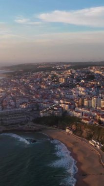 Ericeira City, Sunset, Atlantic Ocean ve Beach 'te. Portekiz. Hava görüntüsü. Drone ileri gidiyor. Dikey Video