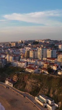 Ericeira City, Sunset, Atlantic Ocean ve Beach 'te. Portekiz. Hava görüntüsü. Drone yukarı ve geri hareket ediyor. Dikey Video