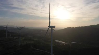 Günbatımında Portekiz 'in Yeşil Kırsal Bölgesinde Rüzgar Türbinleri. Hava görüntüsü. Alternatif Yenilenebilir Enerji. Yörüngede
