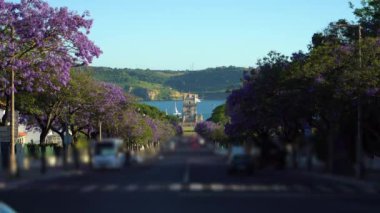 Belem Kulesi, Jacaranda Çiçek açan Mor Mavi Ağaçlar ve Sunny Evening 'de yelkenliler. Altın Saat. Lizbon, Portekiz.
