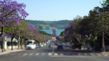 Belem Kulesi, Jacaranda Çiçek açan Mor Mavi Ağaçlar ve Güneşli Gün 'de yelkenli. Tagus Nehri. Lizbon, Portekiz.