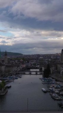 Zürih Eski Şehir Skyline ve Limmat Nehri Bulutlu Gece. İsviçre. Hava görüntüsü. Drone yukarı ve geri hareket ediyor. Dikey Video