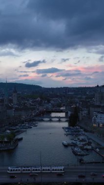 Akşam Alacakaranlığı 'nda Zürih Eski Şehir Skyline ve Limmat Nehri. İsviçre. Hava görüntüsü. Yörüngede. Dikey Video