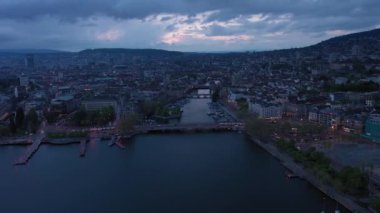Akşam Alacakaranlığı 'nda Zürih Şehri Eski Şehir Skyline ve Limmat Nehri. İsviçre. Hava görüntüsü. İnsansız hava aracı ileri, yana doğru hareket ediyor. Görüntü Görüntüsü
