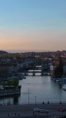 Zürih Eski Şehir Skyline ve Günbatımında Limmat Nehri. Altın Saat. İsviçre. Hava görüntüsü. Drone Yükseliyor. Dikey Video