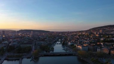 ZURICH, SWitzERLAND - 28 Nisan 2024: Zürih Eski Şehir Skyline ve Sunset Limmat River. Altın Saat. İsviçre. Hava görüntüsü. Drone İleri ve Yukarı Gidiyor