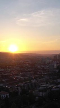 Zürih City, Sunset 'te. Şehrin batı ve kuzey kesimleri. Altın Saat. İsviçre. Hava görüntüsü. İnsansız hava aracı yan yana hareket ediyor. Dikey Video