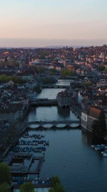 Zürih Şehri Eski Şehir ve Günbatımında Limmat Nehri. Altın Saat. İsviçre. Hava görüntüsü. Yörüngede. Dikey Video